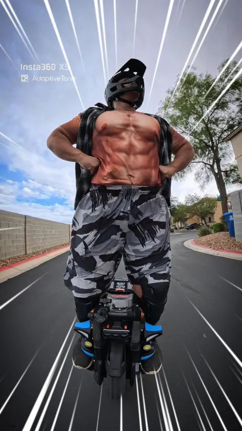 Rider in a helmet standing on an electric unicycle on a residential street